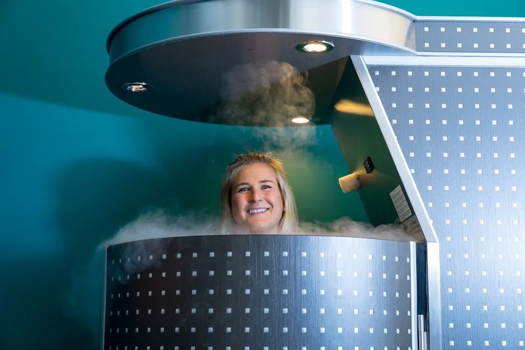 a woman is smiling while standing in a steaming pot with steam coming out of the top of the pot