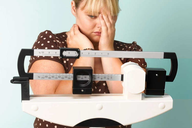 What does Body Mass Index (BMI) mean? Obese teenager on scales concerned the result.